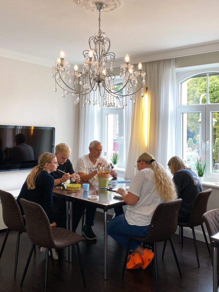 Eine Familie bemalt verschiedene Keramikteile