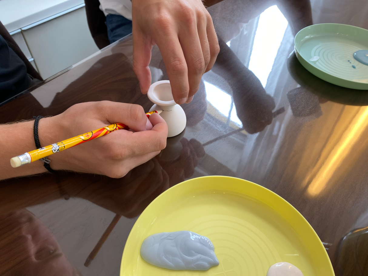 ein Eierbecher bekommt eine Vorzeichnung vor dem Bemalen mit Glasur